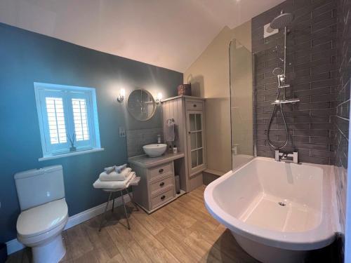 a bathroom with a tub and a toilet and a sink at 2 Bed in Pateley Bridge G0017 in Lofthouse