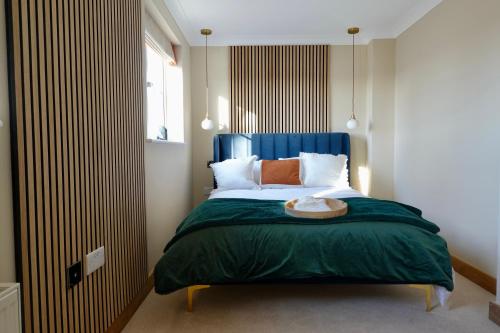 a bedroom with a large bed with a blue headboard at Oakview in Colchester