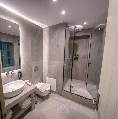 a bathroom with a shower and a sink and a toilet at MAKRIS Papigo Luxury suites in Papigko