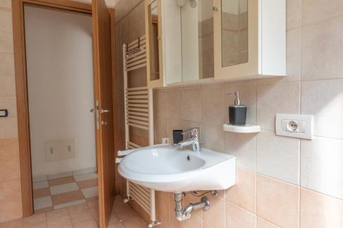 y baño con lavabo blanco y espejo. en Casa Lina en Malcesine