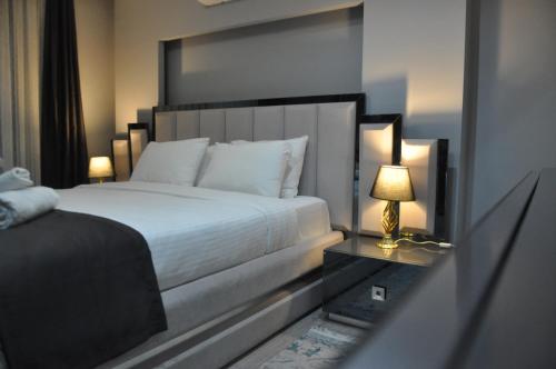 um quarto com uma cama e um candeeiro sobre uma mesa em Dreams Inn Luxury Residences & Lifestyle em Cimenli