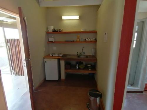 a kitchen with a sink and a small refrigerator at Blyde Mountain Country House in Hoedspruit