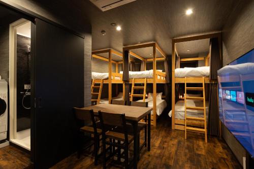 a room with a table and a room with bunk beds at OLD HERITAGE SHIBUYA in Tokyo