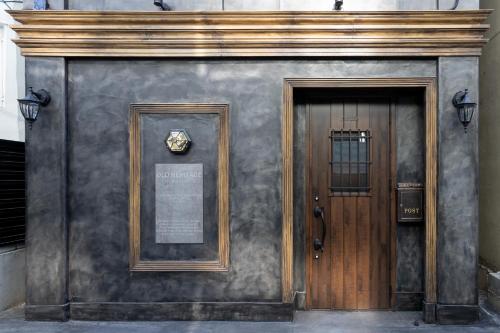 a building with a wooden door and a sign on it at OLD HERITAGE SHIBUYA in Tokyo