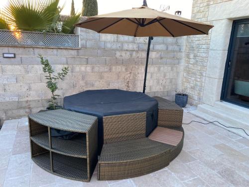 een tafel en stoelen onder een parasol op een terras bij Studio Nîmes in Nîmes