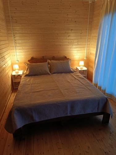 a bedroom with a large bed with two lamps at ANANIA Cottage in Batumi