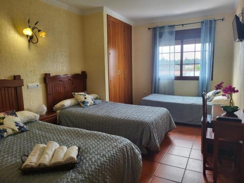 sypialnia z 2 łóżkami i oknem w obiekcie Hostal Rural La Plata Parking Incluido w mieście Arcos de la Frontera