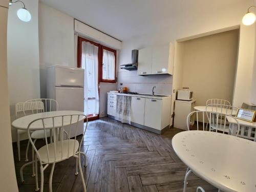 una cocina con 2 mesas y sillas en una habitación en Residenza Cisanello, en Pisa
