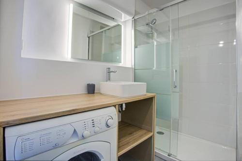 une salle de bain avec une machine à laver et un lavabo dans l'établissement Appartement T2 vue mer moderne et lumineux -4MELIS47, à Canet