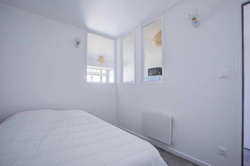 une chambre blanche avec un lit et une fenêtre dans l'établissement Appartement T2 vue mer moderne et lumineux -4MELIS47, à Canet