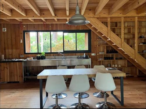 eine Küche mit Tisch und Stühlen und einer Spüle in der Unterkunft Charmant Chalet au bord du lac in Lacanau