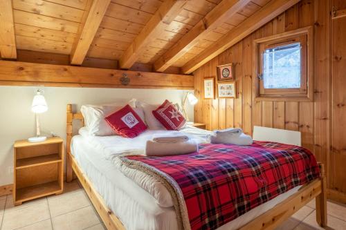 een slaapkamer met een bed in een blokhut bij Le Hameau des Neiges in Les Trabets