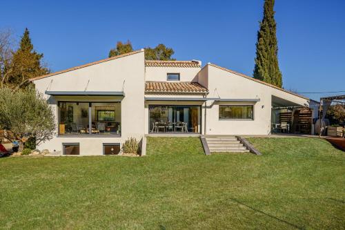 une grande maison blanche avec une cour dans l'établissement VILLA CADELIA Location de villa familiale, à Cabriès