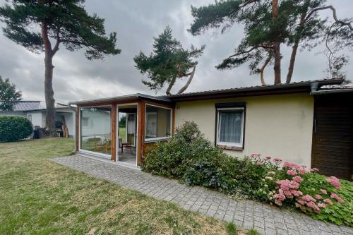 a house with sliding glass doors on a yard at Bungalow Am Richtberg in Quetzin