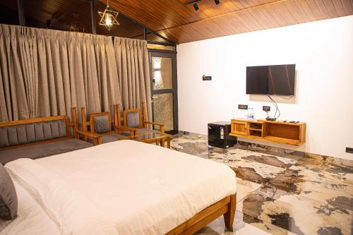 a bedroom with a bed and a flat screen tv at White Sand Beach Resort in Kondivli