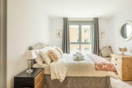 a white bedroom with a bed and a window at Lovely 1 bed Station flat - Central With Sofa Bed in Cambridge