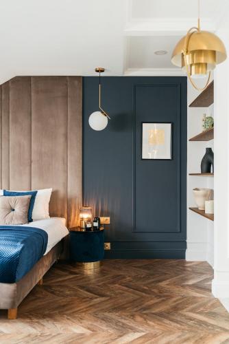 a bedroom with a bed and a blue wall at Central Palace - LoftAffair Collection in Kraków