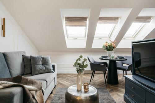 a living room with a couch and a tv at Central Palace - LoftAffair Collection in Kraków