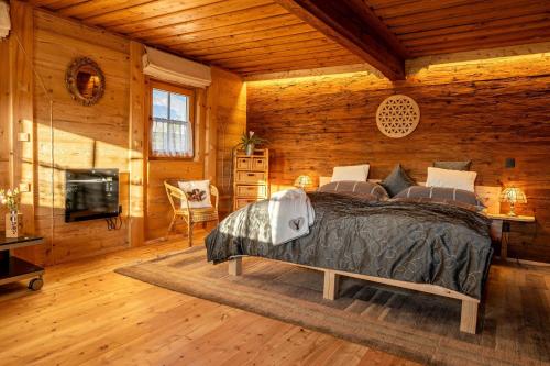 ein Schlafzimmer mit einem Bett in einem Zimmer mit Holzwänden in der Unterkunft Bauernhaus Untermoos in Breitenbach am Inn