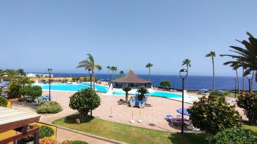 un complejo con piscina y el océano en el fondo en Rocas del Mar 327, en Costa del Silencio