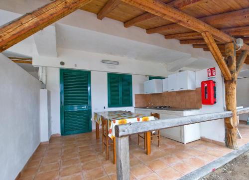 une cuisine avec une table et des volets verts dans l'établissement Accommodetion "Mare Grande", à Tropea