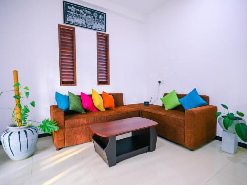 a living room with two couches with colorful pillows at Annasi Villa in Hikkaduwa