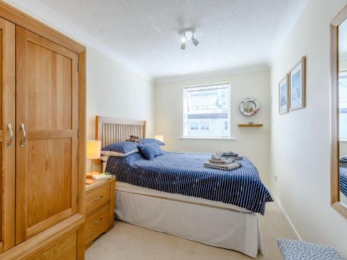 a bedroom with a blue bed and a window at 1 Bed in Milford on Sea 79332 in Milford on Sea