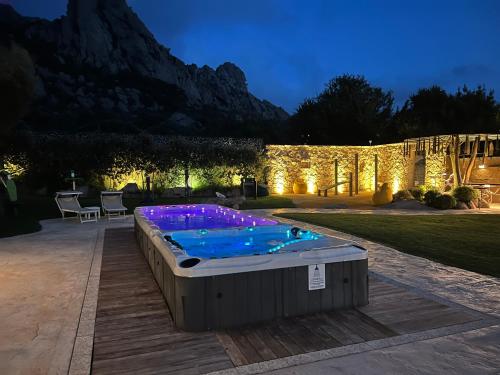 a swimming pool in the middle of a yard at night at Antica Fonte Holiday Homes in San Pantaleo