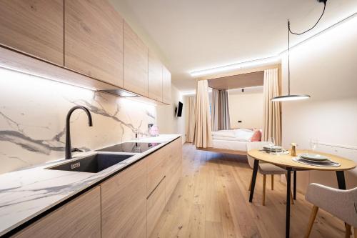 a kitchen with a sink and a table at Avia Living Anna in Brunico