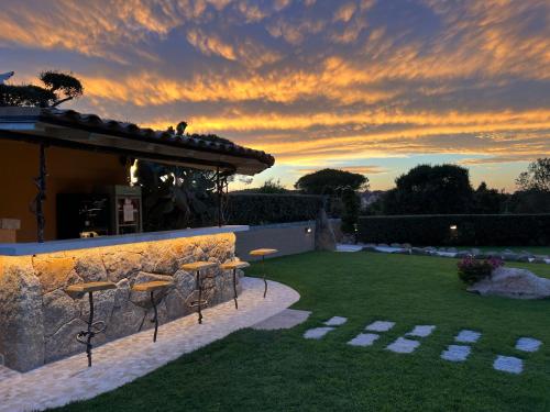 a patio with chairs and a bar in a yard at Antica Fonte Holiday Homes in San Pantaleo