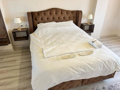 a bed with two towels and two shoes on it at Triplex house 2 in Arnavutköy