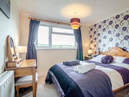 1 dormitorio con cama, escritorio y ventana en 3 Bed in Cantref BN363, en Brecon