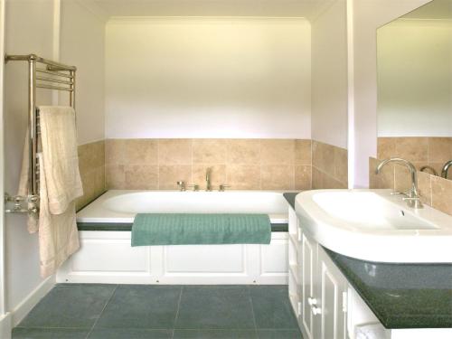 a bathroom with a white tub and a sink at 5 Bed in Kilfinan CA007 in Kilfinan