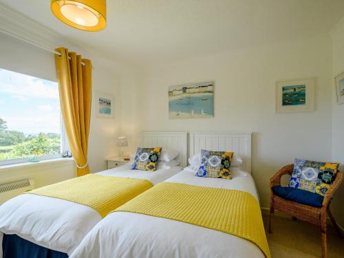 two beds in a bedroom with a window at 1 Bed in Brodick CA308 in Brodick