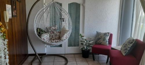 a room with a hanging swing and a chair at Goshen in Johannesburg