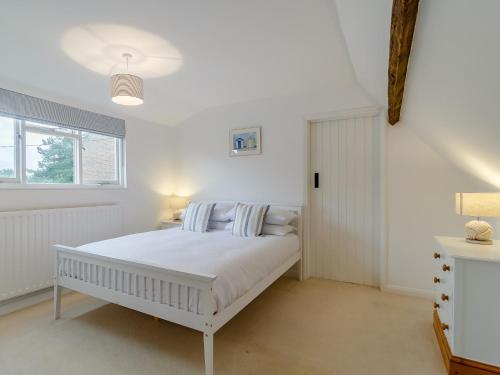 a white bedroom with a white bed and a window at 3 Bed in Old Hunstanton 78821 in Hunstanton
