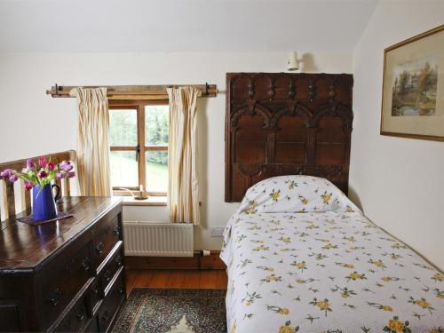 um quarto com uma cama, uma cómoda e uma janela em 1 Bed in Crickhowell BN144 em Llanbedr