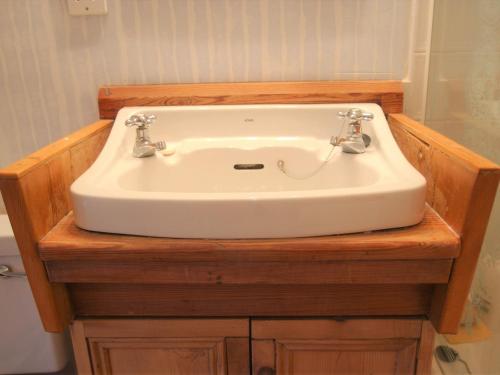 lavabo blanco en una encimera de madera en el baño en 1 Bed in Crickhowell BN144 en Llanbedr