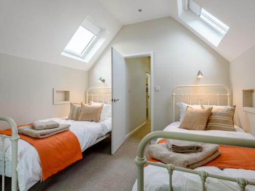 two beds in a attic bedroom with skylights at 4 Bed in Llandudno 80288 in Rhôs-on-Sea