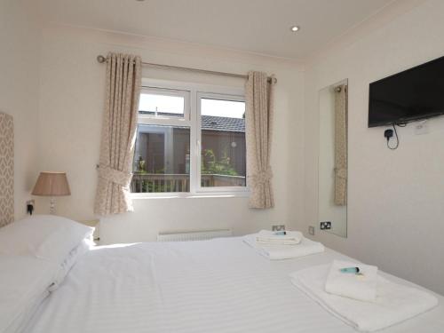 a bedroom with a white bed and a window at 2 Bed in Okehampton 80373 in Okehampton