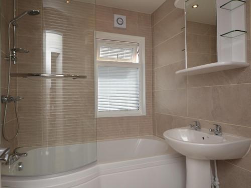 a bathroom with a tub and a sink and a toilet at 2 Bed in Okehampton 80373 in Okehampton