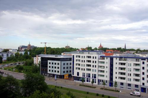 un grande edificio bianco in una città con una strada di Ferienwohnung "Am Vögenteich" a Rostock