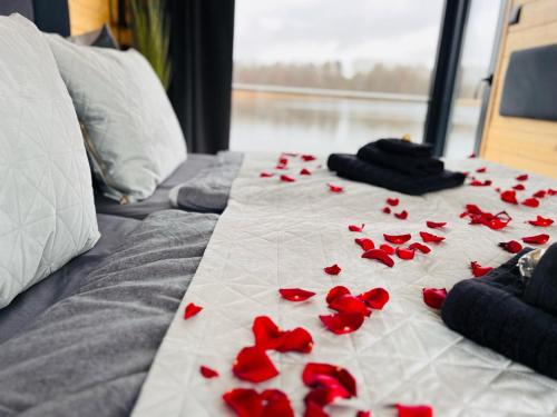 a bunch of red roses laying on a bed at Seezeit im Hausboot mit Kamin & Sauna in Müllrose