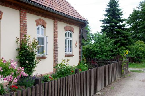 a house with a fence in front of it at Ferienwohnung Haus am See in Ulrichshusen