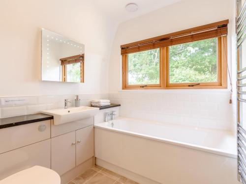 a white bathroom with a tub and a sink at 1 Bed in Rolvenden 76565 in Rolvenden
