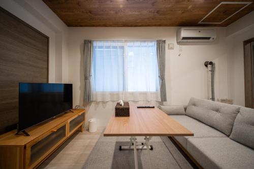 a living room with a couch and a flat screen tv at ASPIRE【2min from Asahikawa sta】 in Asahikawa