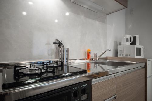 a kitchen with a stove and a sink at ASPIRE【2min from Asahikawa sta】 in Asahikawa