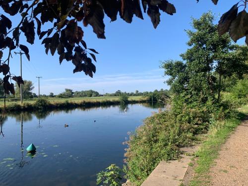 a river with a green boat in the water at Comfy, cozy house with disabled access in St. Ives