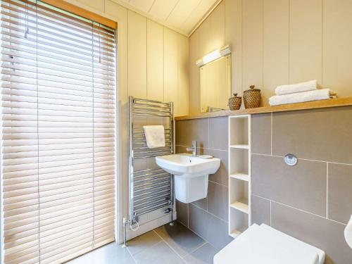 a bathroom with a sink and a toilet and a mirror at 2 Bed in Caldbeck 80562 in Caldbeck