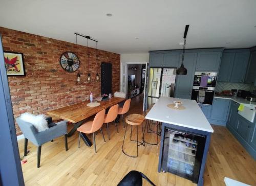 a kitchen with a table and chairs and a brick wall at Kent village house 